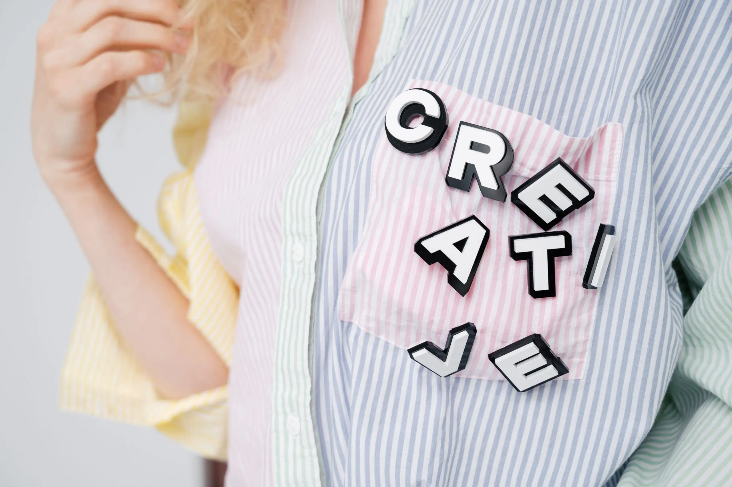Fotoausschnitt eine Frau trägt eine Bluse mit Buchstaben CREATIVE